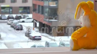 黄色玩具小兔子坐在窗台上.. 雪花<strong>飘落</strong>